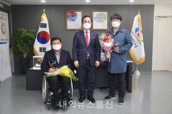 박상돈 천안시장이 23일 임기 만료로 퇴임하는 김형규 장애인체육회 사무국장과 유영근 축구단 사무국장에게 공로패를 전달하고 기념사진을 찍고 있다.(사진제공-천안시청)