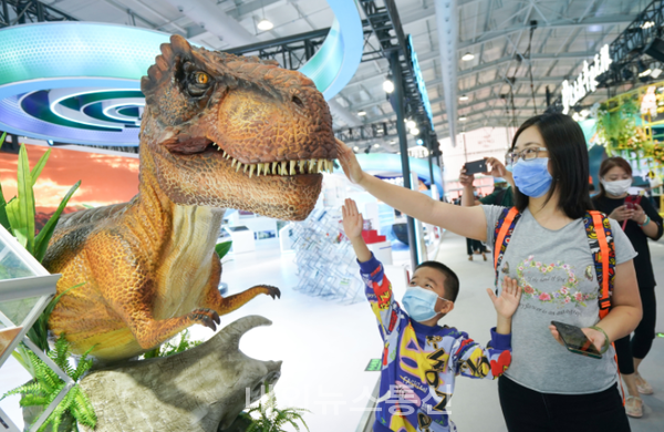 CIFTIS 서우강산업단지 문화관광서비스 전시관을 찾은 모자 관람객이 4일 공룡 모형을 구경하고 있다. (사진=신화통신 )