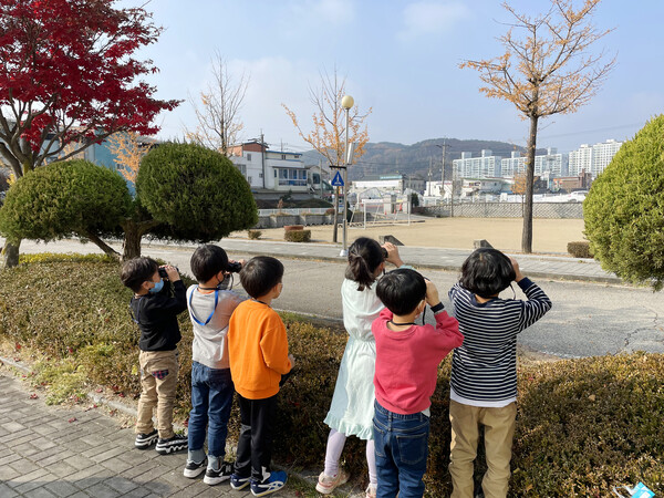 숲체원 '꿈잡고 숲잡고' 프로그램에서 아이들이 망원경으로 무언갈 관찰하고 있다. (사진=횡성군청 제공)