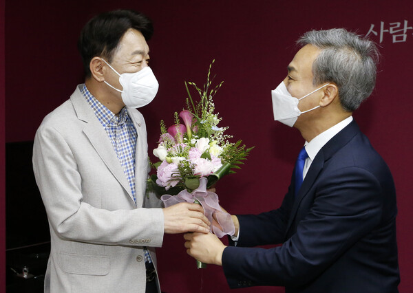 우범기 전주시장 당선인이 퇴임하는 김승수 시장(오른쪽)에게 꽃다발을 전하고 있다.(사진=전주시)